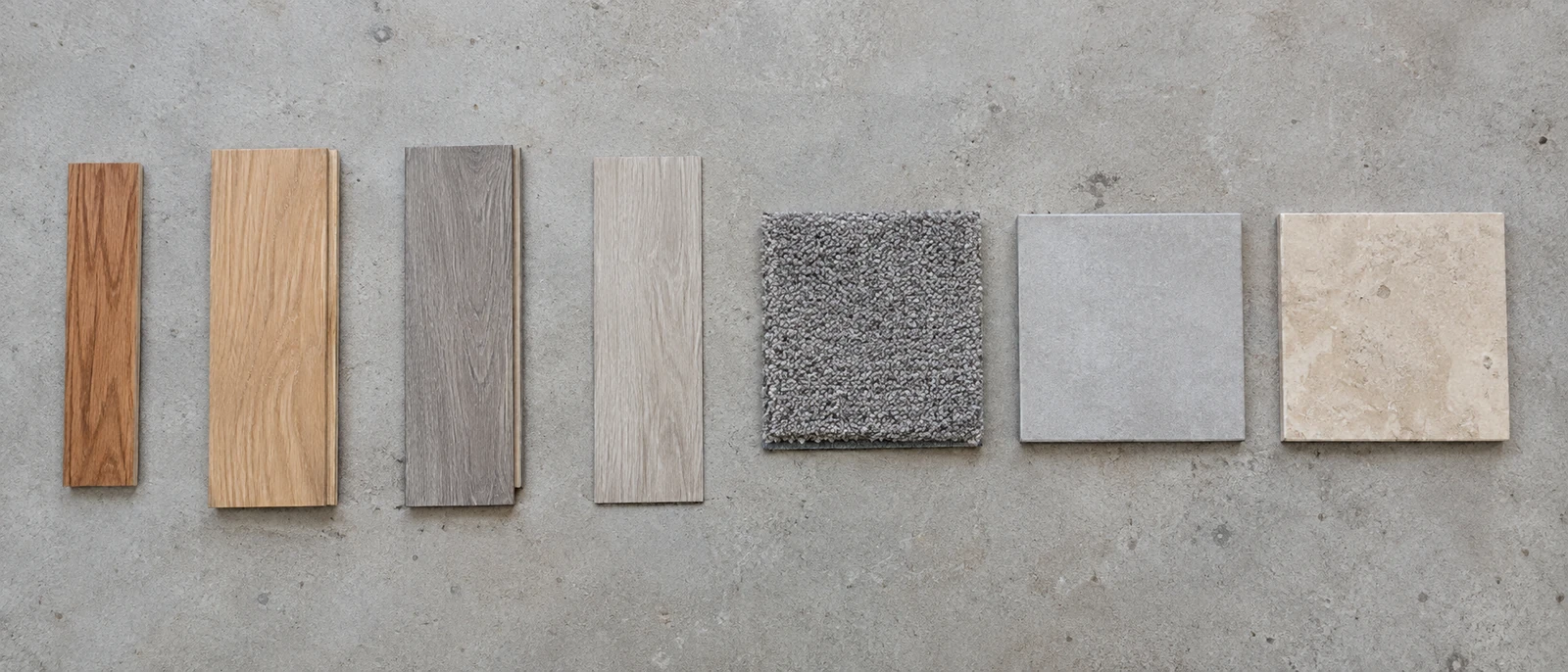 AI-generated illustration of seven flooring samples side by side: solid oak, engineered oak, laminate, vinyl plank, carpet, porcelain tile and natural stone.